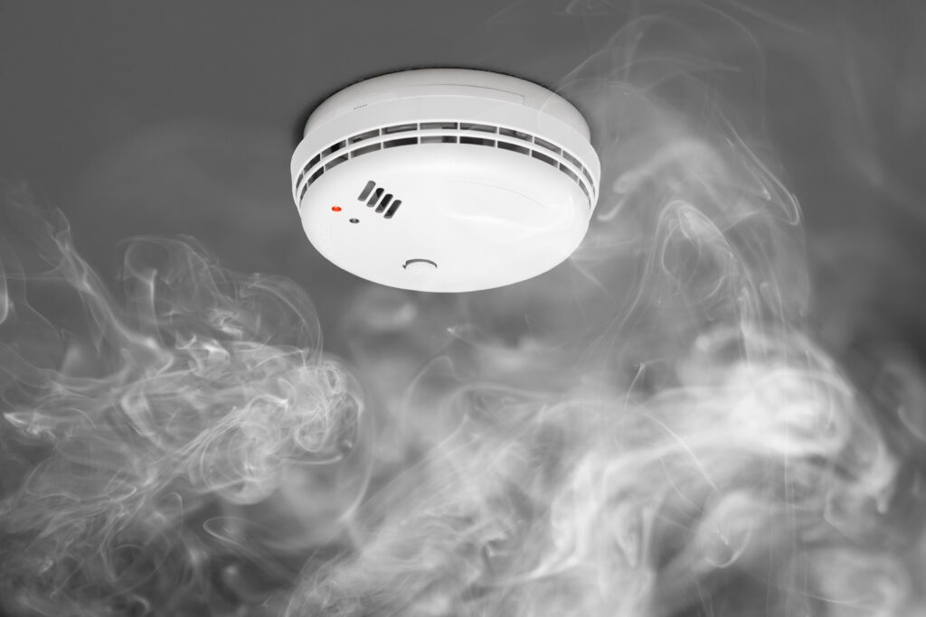 Electrician wiring a smoke detector system in a new home