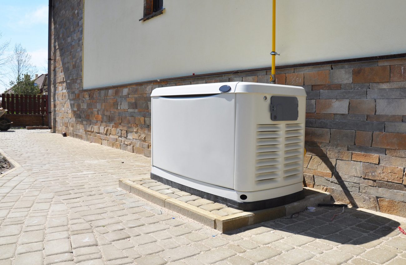 Electrician installing a backup generator outside a residential home in Kentucky